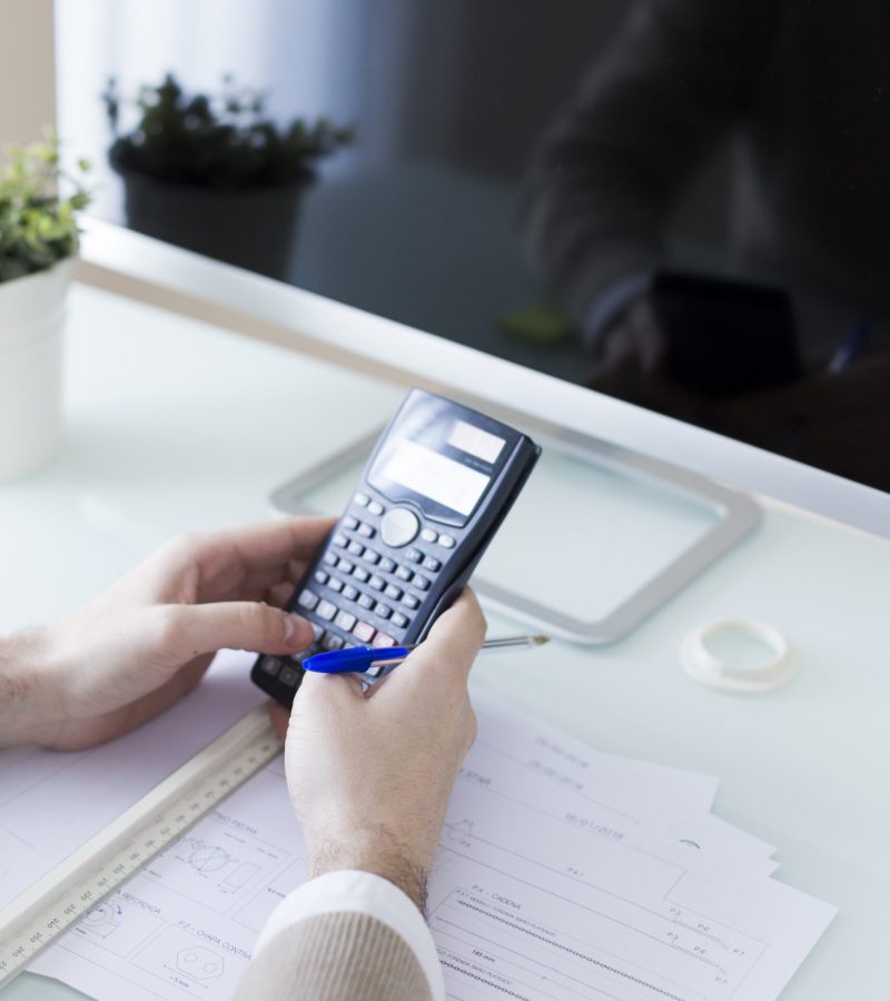 crop-hands-using-calculator-near-monitor
